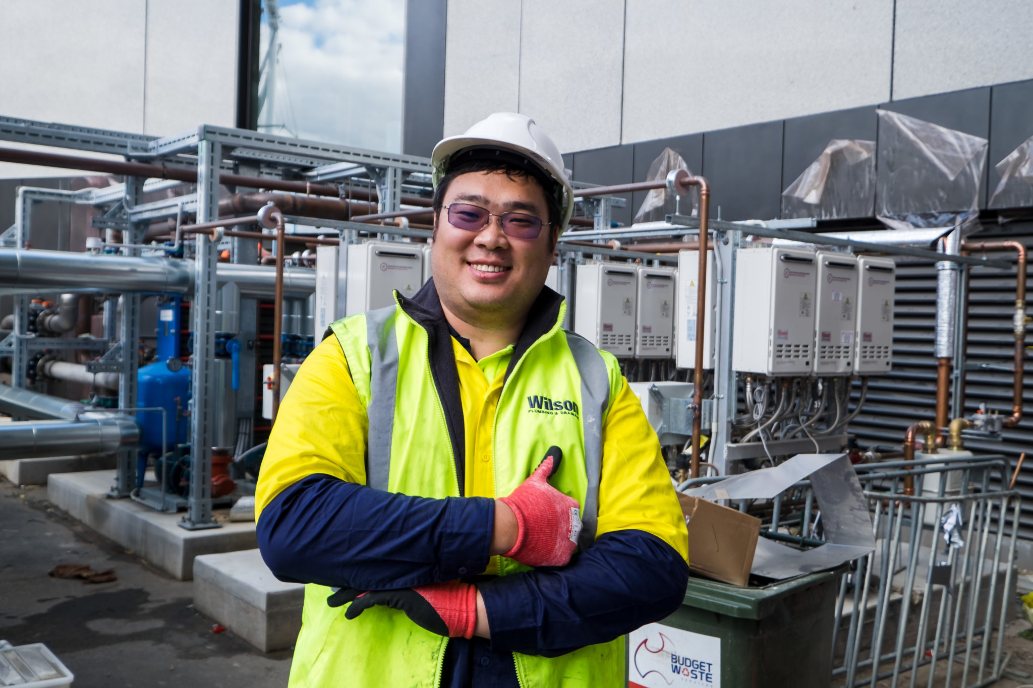 An apprentice, standing in front of HVAC equipment