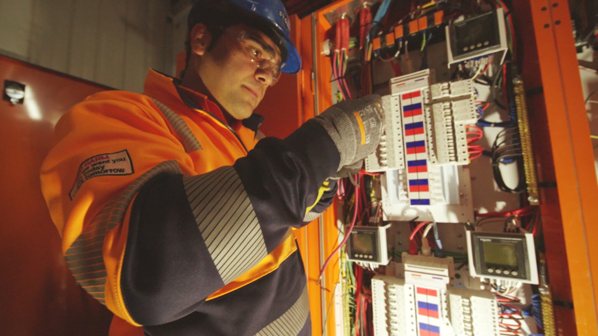 An electrical apprentice, working safely with personal protective equipment