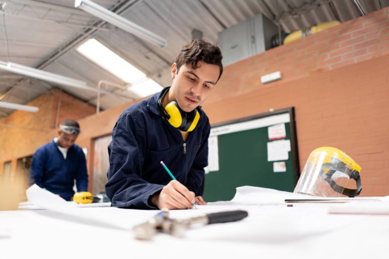 Apprentice seated at desk.