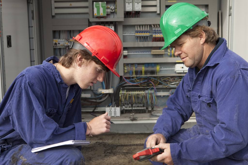 Apprentice working with a mentor in a hands-on training environment.