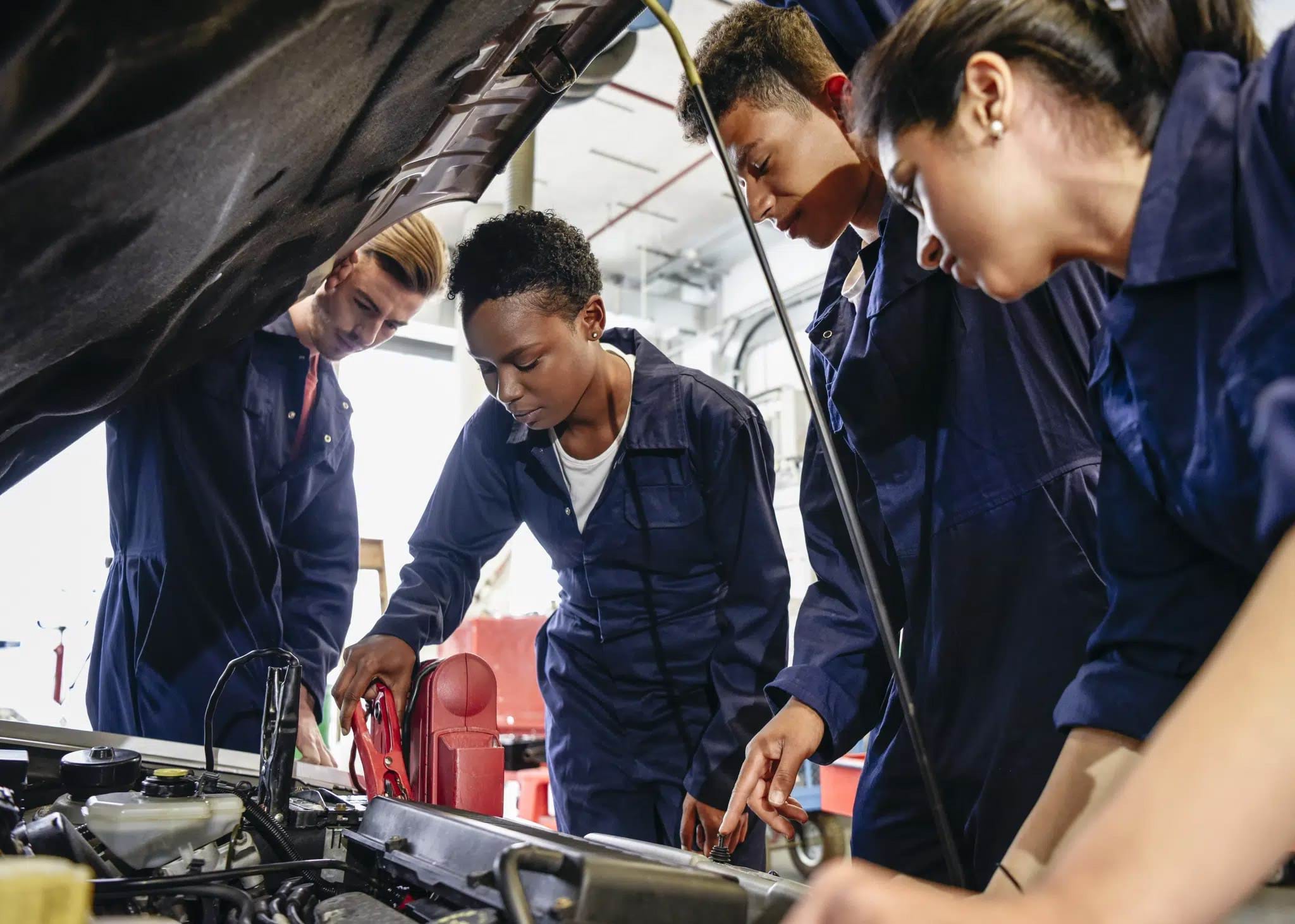 Automotive apprentices working on an engine