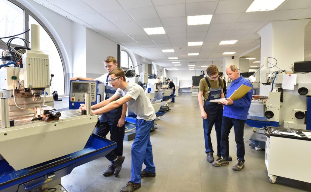 Apprentices working on machinery and tech equipment